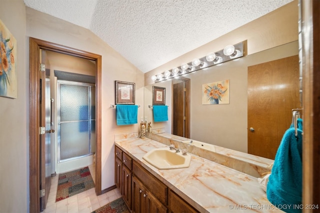 bathroom with tile patterned flooring, a textured ceiling, lofted ceiling, a shower with door, and vanity