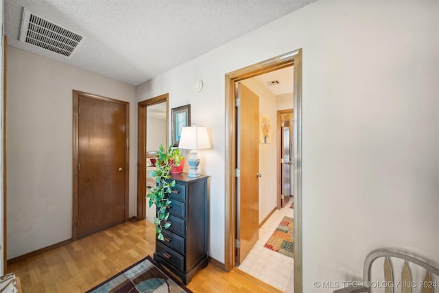 interior space featuring a textured ceiling and light hardwood / wood-style flooring