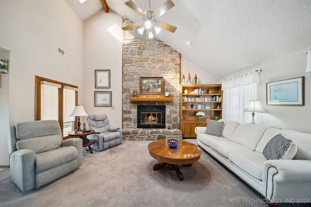 carpeted living room featuring beam ceiling, a stone fireplace, high vaulted ceiling, and a textured ceiling