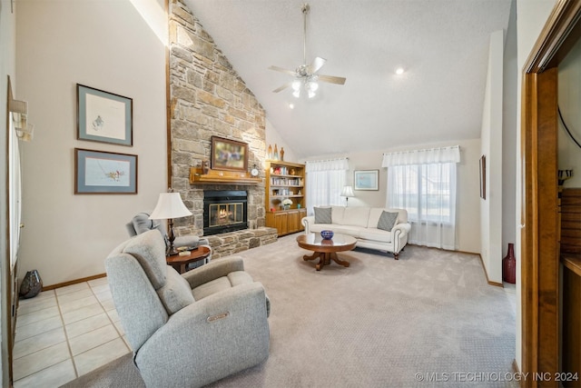 living room featuring a textured ceiling, ceiling fan, high vaulted ceiling, a fireplace, and light tile patterned flooring