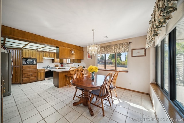 tiled dining room featuring a notable chandelier