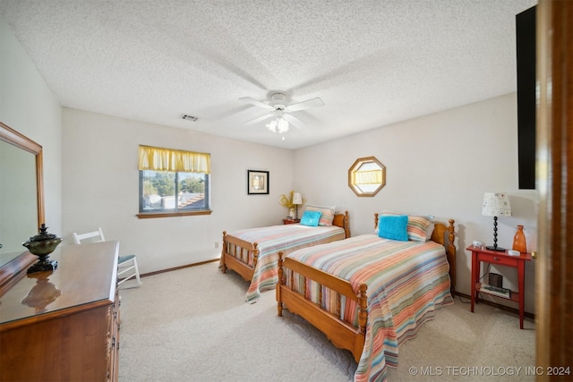 carpeted bedroom with ceiling fan and a textured ceiling