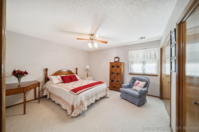 bedroom featuring carpet, ceiling fan, and a textured ceiling