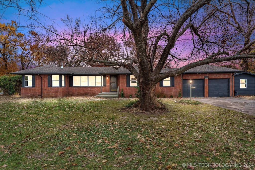 single story home with a garage and a lawn