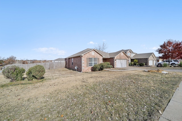 ranch-style house with a garage and a front lawn