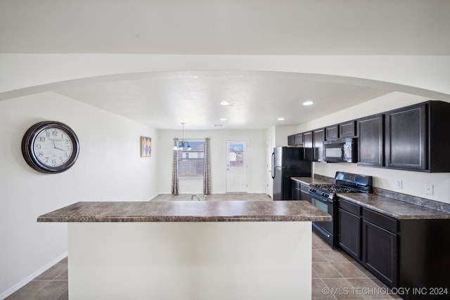 kitchen with an inviting chandelier, decorative light fixtures, a kitchen island, and black appliances