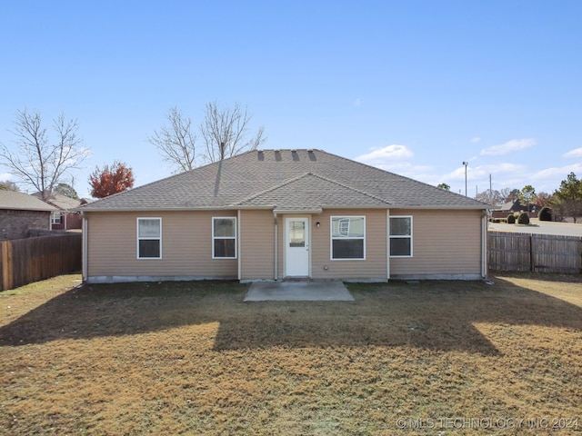 rear view of property featuring a yard and a patio