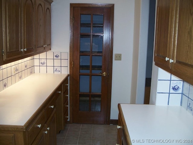 kitchen featuring dark tile patterned flooring and decorative backsplash