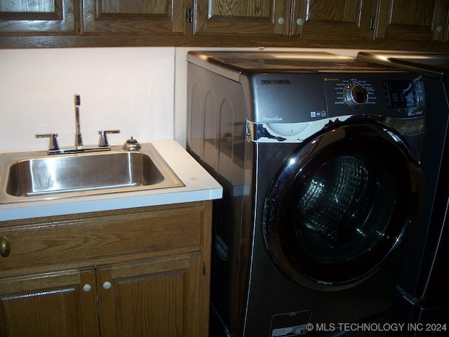 laundry area with cabinets, washer / clothes dryer, and sink