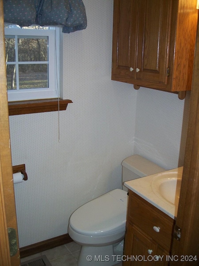 bathroom featuring tile patterned flooring, vanity, and toilet