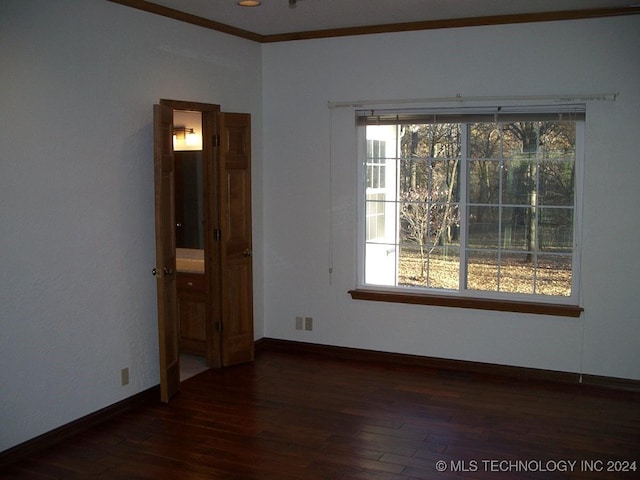 empty room featuring plenty of natural light, dark hardwood / wood-style floors, and ornamental molding