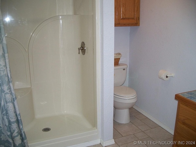 bathroom featuring tile patterned floors, curtained shower, and toilet