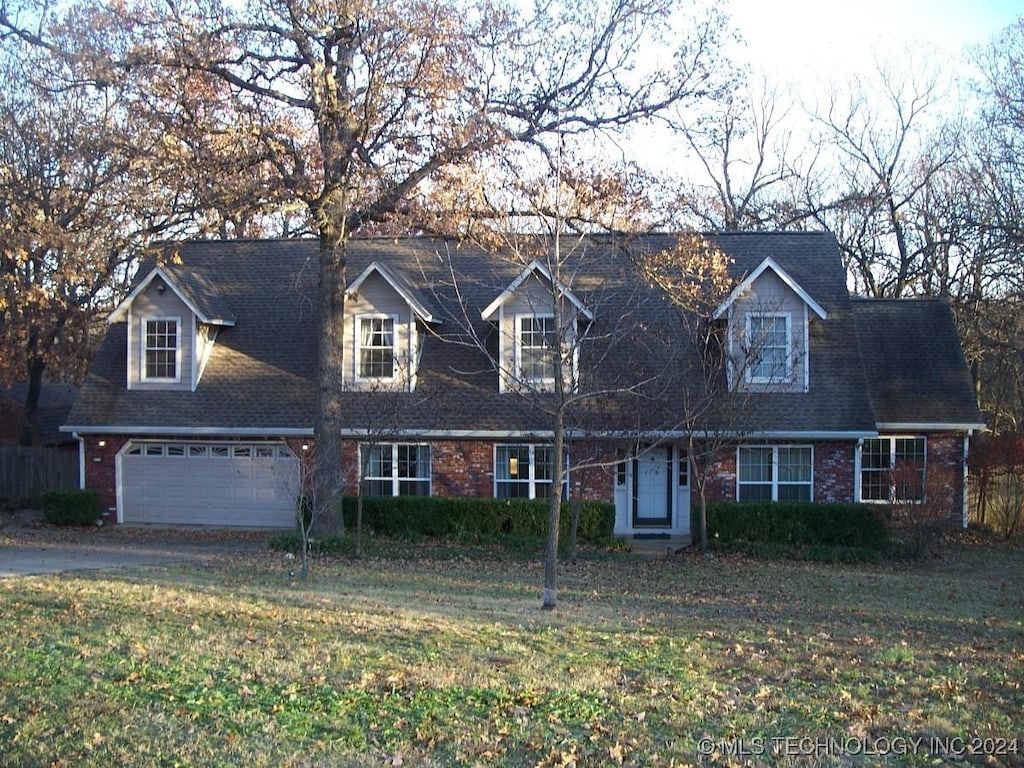 cape cod-style house with a front lawn and a garage
