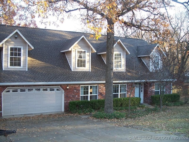 cape cod-style house featuring a garage