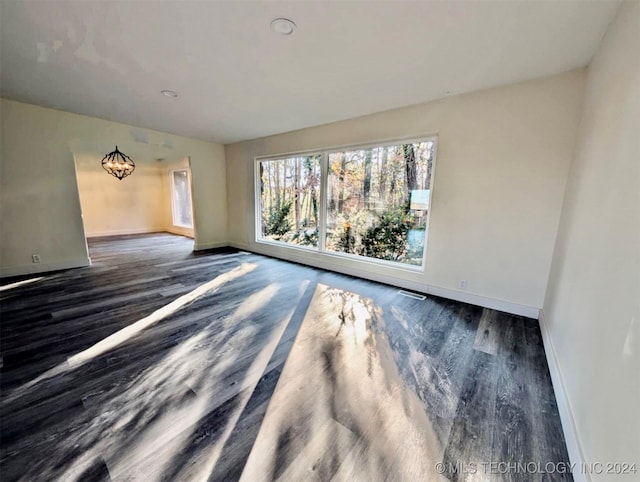 unfurnished room with dark wood-type flooring