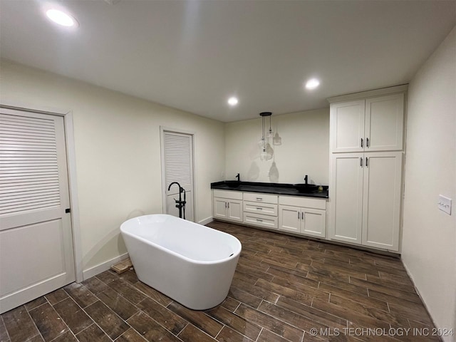 bathroom featuring vanity, hardwood / wood-style flooring, and a bathing tub