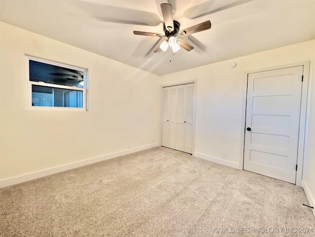 unfurnished bedroom featuring ceiling fan, a closet, and light carpet