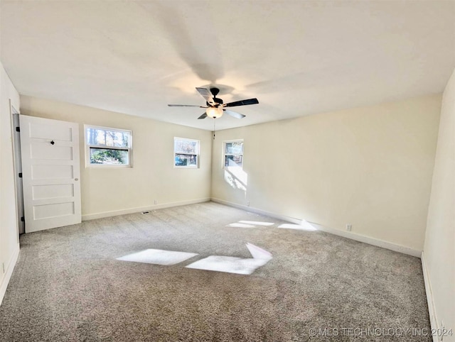 carpeted spare room with ceiling fan