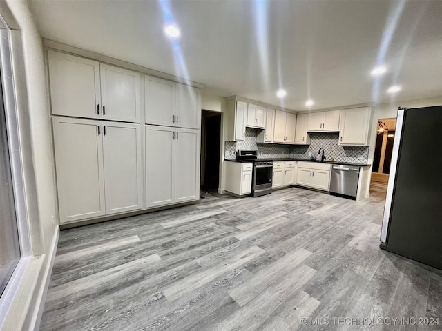 kitchen with sink, white cabinets, stainless steel appliances, and light wood-type flooring