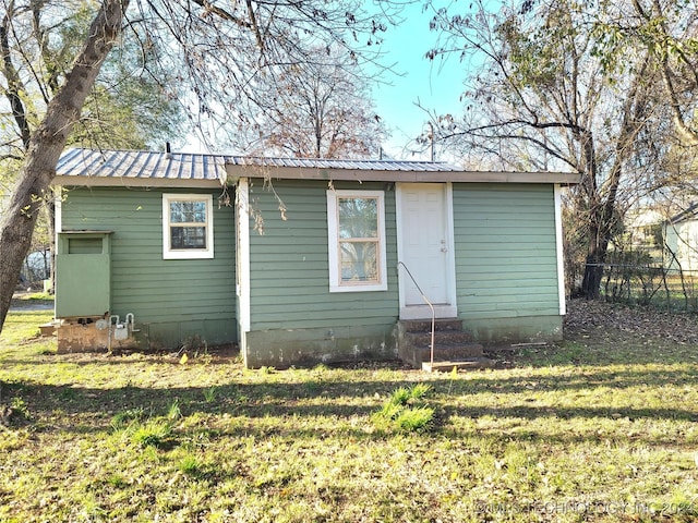 rear view of property featuring a lawn