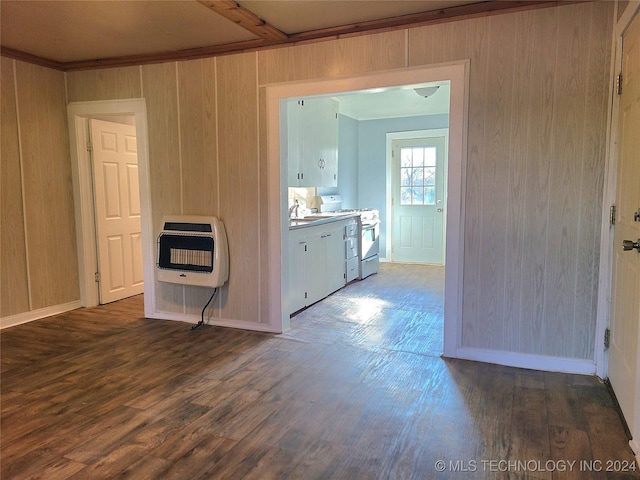 interior space with dark hardwood / wood-style flooring, heating unit, and wooden walls