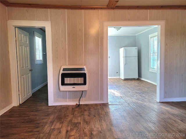 kitchen with dark hardwood / wood-style flooring, ornamental molding, heating unit, white fridge, and wood walls