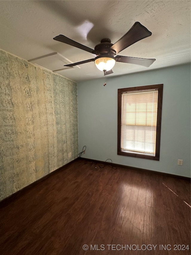 spare room featuring a textured ceiling, dark hardwood / wood-style floors, and ceiling fan