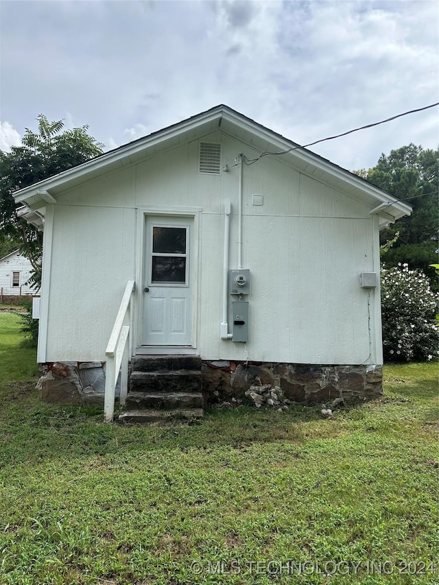 rear view of property featuring a yard