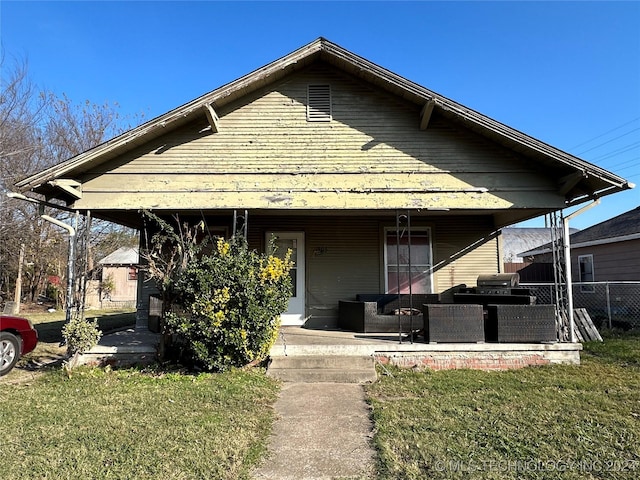 view of front of property with a front yard, fence, and an outdoor living space