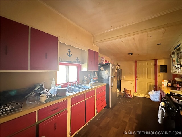 kitchen with dark wood finished floors, red cabinets, freestanding refrigerator, black range, and a sink