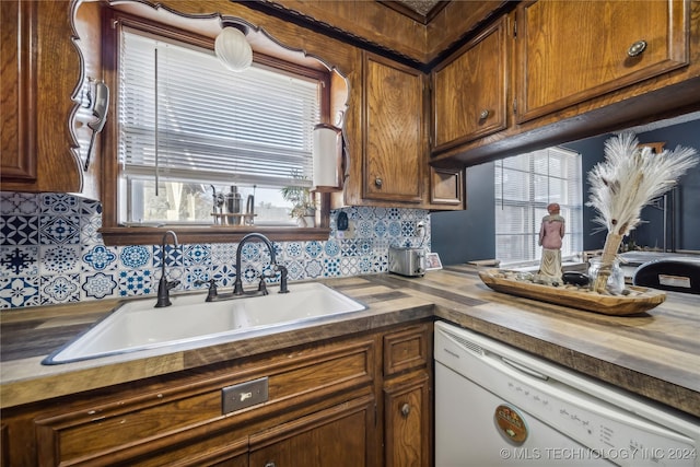 kitchen with decorative backsplash, butcher block countertops, dishwasher, and sink