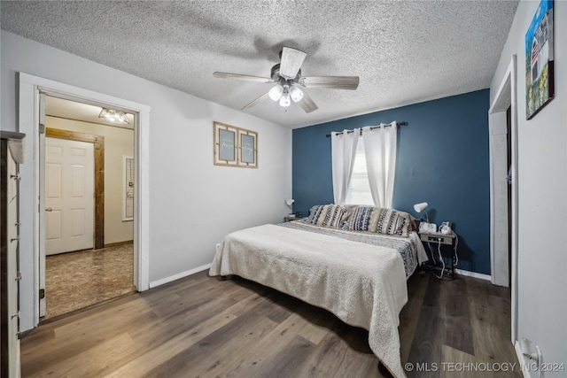 bedroom with ceiling fan, wood-type flooring, and a textured ceiling