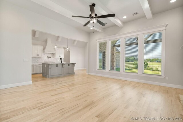 2601 W Twin Oaks St, Broken Arrow, OK 74012 - unfurnished living room with beamed ceiling, plenty of natural light, baseboards, light wood-style flooring, and recessed lighting