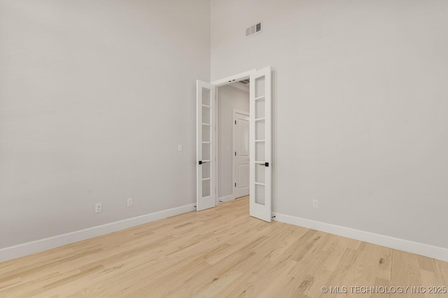 2601 W Twin Oaks St, Broken Arrow, OK 74012 - unfurnished room featuring baseboards, wood finished floors, french doors, and a high ceiling