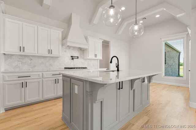 2601 W Twin Oaks St, Broken Arrow, OK 74012 - kitchen with custom exhaust hood, a sink, decorative backsplash, a kitchen island with sink, and white cabinets