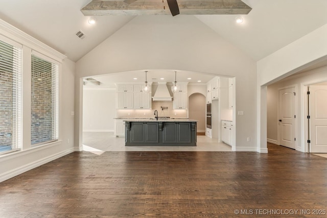 17413 S 52nd E Ave, Bixby, OK 74008 - unfurnished living room with high vaulted ceiling, arched walkways, beam ceiling, light wood-style flooring, and a sink
