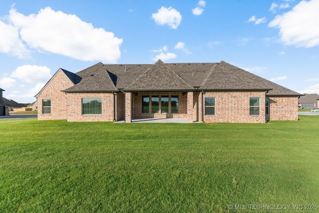 17413 S 52nd E Ave, Bixby, OK 74008 - back of property featuring brick siding, a lawn, roof with shingles, and a patio area