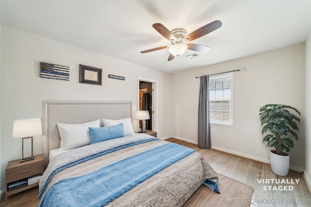 bedroom featuring a walk in closet, ceiling fan, a closet, and hardwood / wood-style flooring