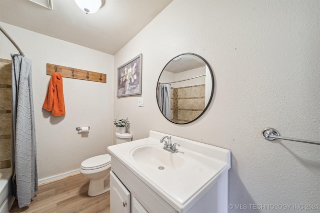 full bathroom featuring wood-type flooring, vanity, toilet, and shower / tub combo with curtain