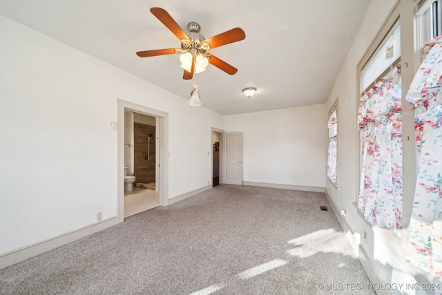 unfurnished bedroom with ceiling fan, carpet floors, and ensuite bath