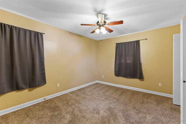 carpeted spare room with ceiling fan