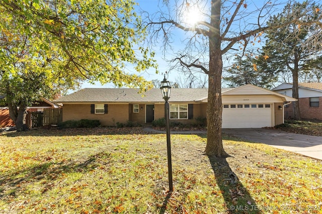 ranch-style house featuring a front lawn and a garage