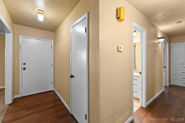 hall featuring dark hardwood / wood-style flooring and a textured ceiling