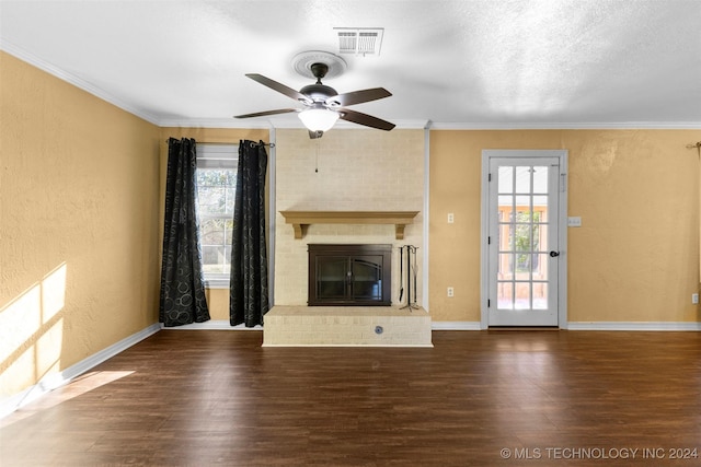 unfurnished living room with hardwood / wood-style floors, a healthy amount of sunlight, and a brick fireplace