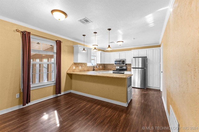 kitchen with kitchen peninsula, stainless steel appliances, sink, decorative light fixtures, and white cabinetry