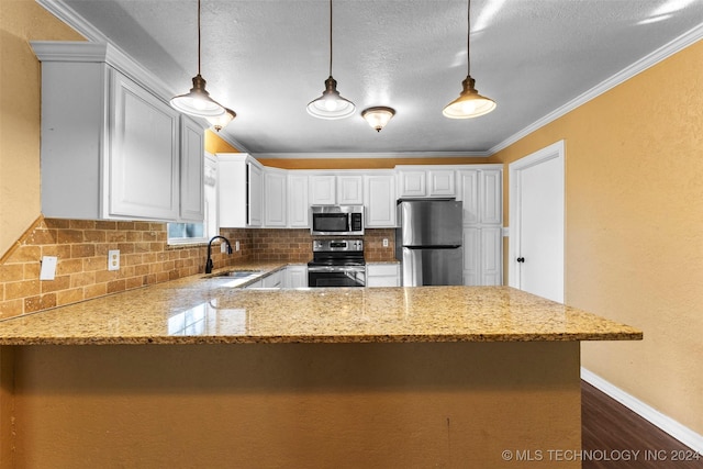 kitchen featuring appliances with stainless steel finishes, white cabinetry, hanging light fixtures, and sink