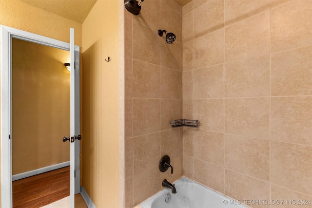 bathroom featuring hardwood / wood-style floors and tiled shower / bath combo