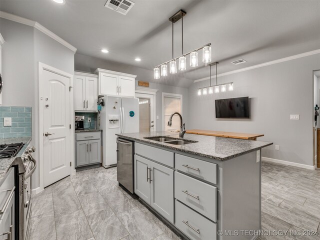 kitchen with backsplash, a kitchen island with sink, sink, gray cabinets, and stainless steel appliances