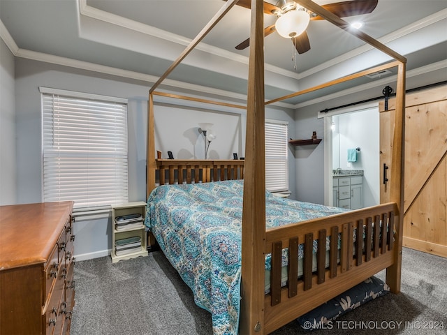 carpeted bedroom with a raised ceiling, a barn door, ceiling fan, and crown molding