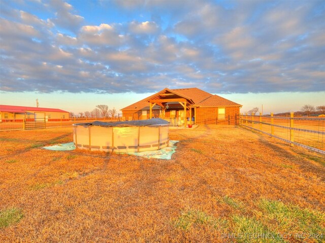 view of yard featuring a gazebo, a rural view, and a covered pool